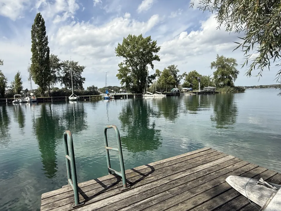 große UFERPAZRELLE mit privatem Badesteg am Neufelder See – Holzhaus mit Renovierungsbedarf beim Yachtclub auf Pachtgrund zu verkaufen - Bild