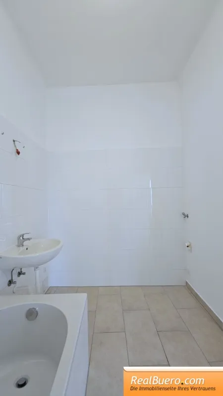 Badezimmer mit Wanne, Handwaschbecken und Waschmaschinenanschluss