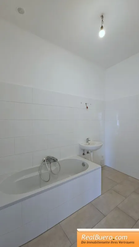 Badezimmer mit Wanne, Handwaschbecken und Waschmaschinenanschluss