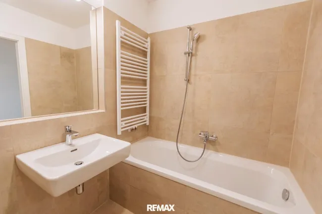 geschmackvolles Badezimmer mit Badewanne und Sprossenheizkörper