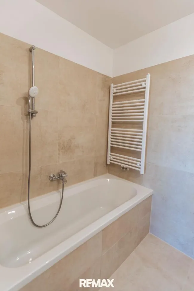 Badezimmer mit Badewanne und Sprossenheizkörper