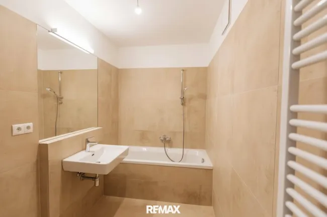 Badezimmer mit Badewanne und Sprossenheizkörper