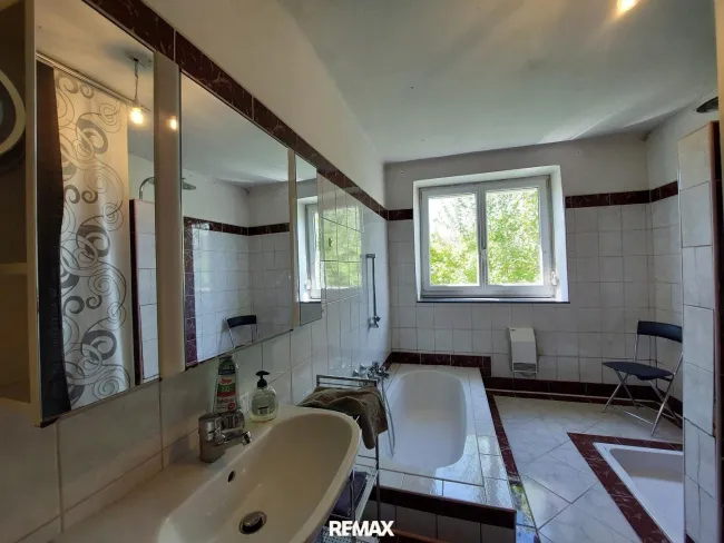 Badezimmer mit versenkter Badewanne und Dusche