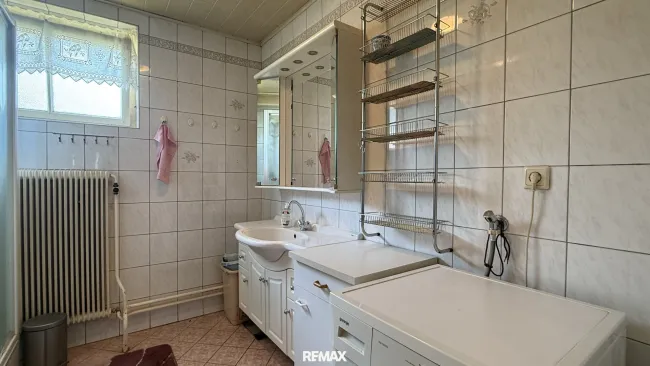 Badezimmer mit Dusche und Waschmaschine