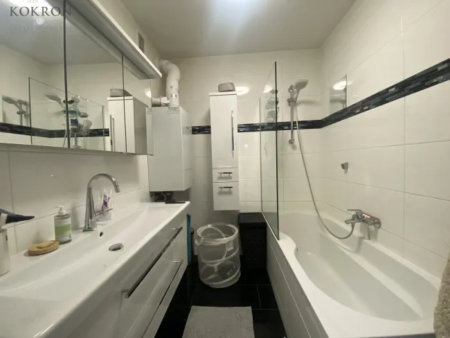Zeitloses Bad mit Badewanne und großzügigem Waschtisch.