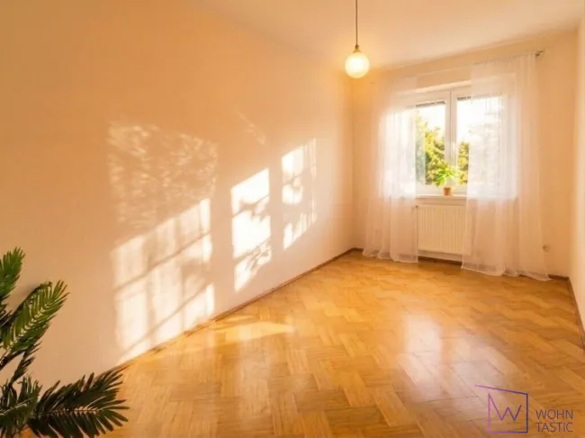 Schlafzimmer mit Holzparkett und Grünblick