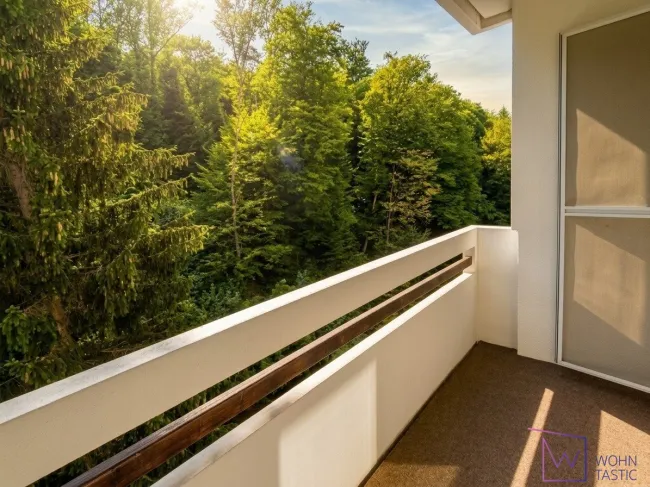 Wohnzimmer mit Loggiazugang und Grünblick
