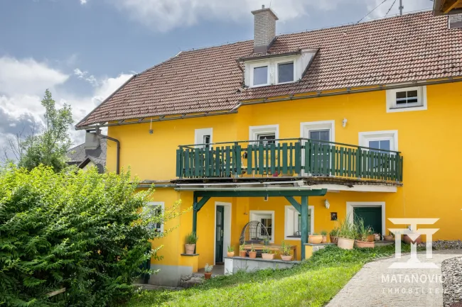 Rückansicht mit Balkon und überdachter Terrasse