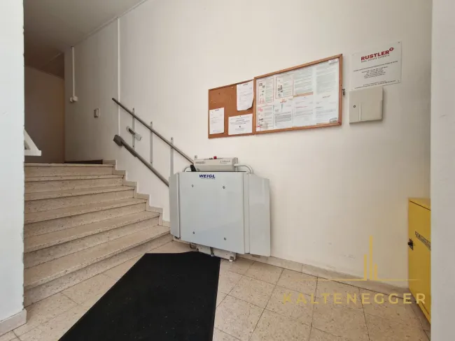 Stiegenhauseingang mit Treppenlift, Postkasterl und Postboxen