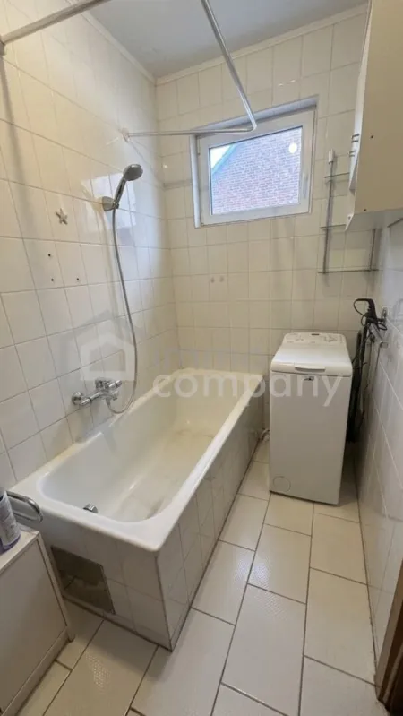 Badezimmer mit Wanne, Fenster und Waschmaschinenanschluss