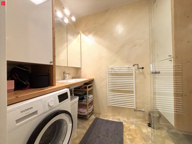 Badezimmer mit Tischlermöbeln und Handtuchtrockner