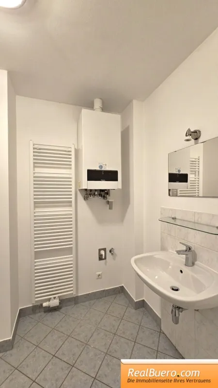 Badezimmer mit Wanne, Handwaschbecken, Handtuchtrockner, Waschmaschinenanschluss