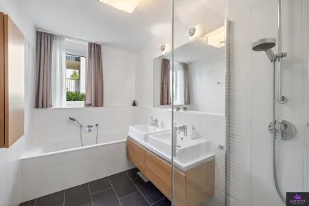 Badezimmer mit Badewanne, Dusche, Doppelwaschbecken & natürlichem Licht
