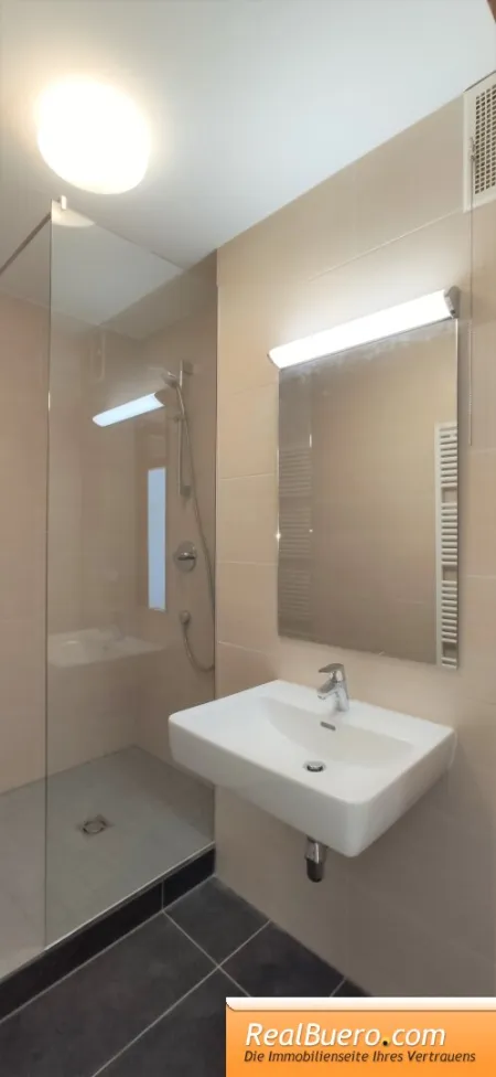 Badezimmer mit Dusche, Handwaschbecken und Sprossenheizkörper