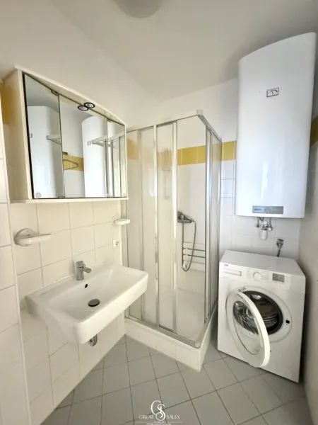 Badezimmer mit Dusche und Waschmaschinenanschluss