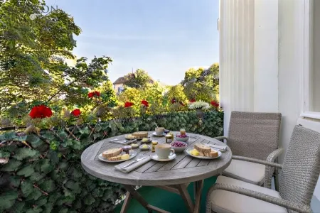 Frühstück am Balkon mit Grünblick (KI hat den Tisch gedeckt)