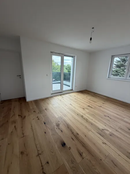 Schlafzimmer mit Ausgang auf Balkon im Haus 1