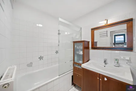 Helles Badezimmer mit Badewanne und Glasabtrennung