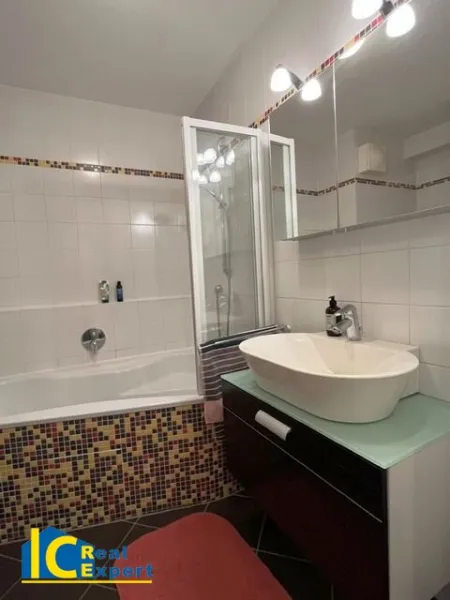 Badezimmer mit Badewanne, Waschtisch und Waschmaschinenanschluss