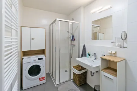 Badezimmer mit Dusche und Waschmaschinenanschluss