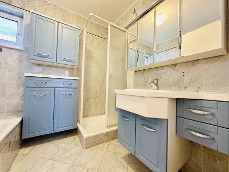 Badezimmer mit Badewanne, Dusche und Fenster
