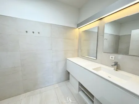 Modernes Badezimmer mit großzügigem Waschtisch und indirekter Beleuchtung