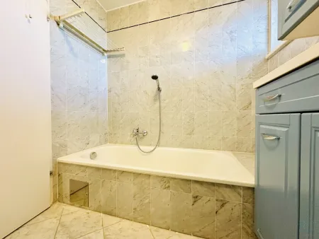 Badezimmer mit Badewanne, Dusche und Fenster