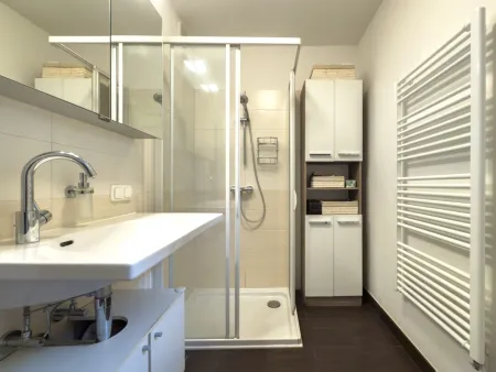 Badezimmer mit Dusche, Fenster und Waschmaschinenanschluss