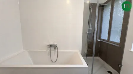 Badezimmer mit Badewanne und Dusche