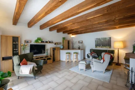 Wohnzimmer mit Fußbodenheizung, Kachelofen und offenem Kamin
