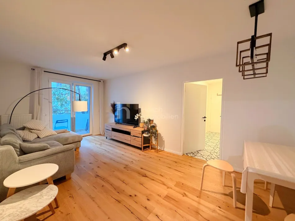 Wohnzimmer mit Sofa und Balkonzugang