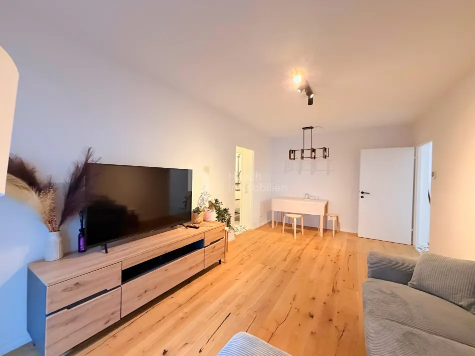 Wohnzimmer mit Sofa und Balkonzugang