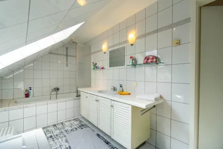 Badezimmer mit Badewanne und Waschmaschinenanschluss DG
