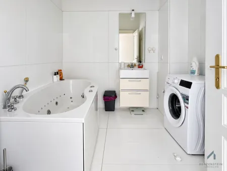 Badezimmer mit Badewanne, WC und Waschmaschinenanschluss