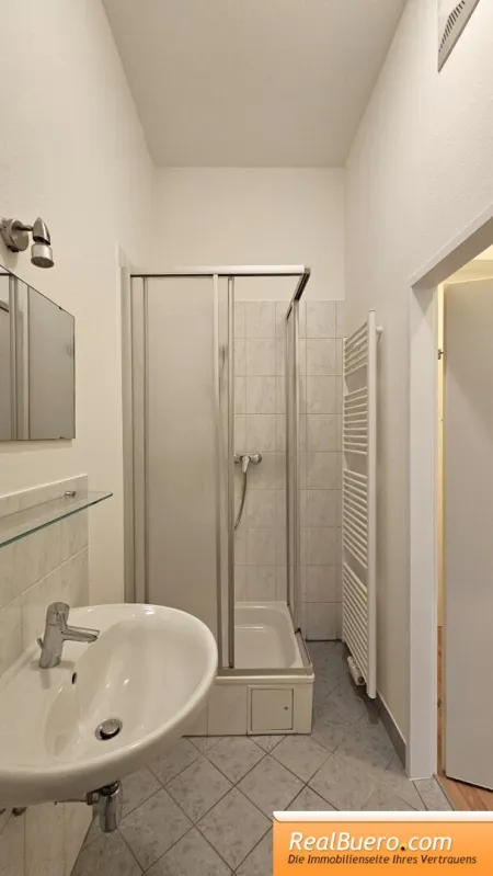 Badezimmer mit Dusche, Handwaschbecken, Waschmaschinenaschluss und Toilette