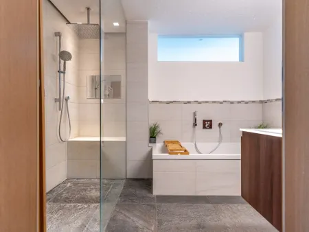 Badezimmer mit Regendusche und Badewanne