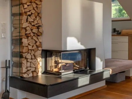 Moderner Kachelofen mit Sitzbank und Holzlager