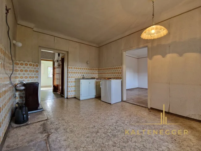 ehemalige Küche mit Zugang zu einem Zimmer und dem Raum mit Kachelofen
