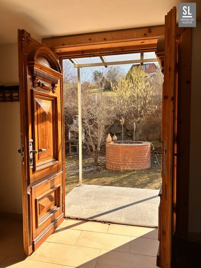 Blick aus dem Haus zum Brunnen