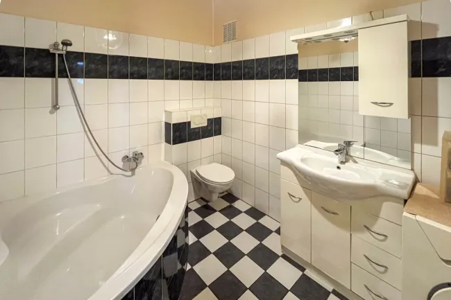 Badezimmer mit Wanne, WC und Waschmaschinenanschluss