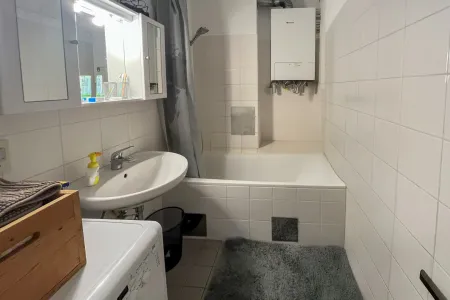 Badezimmer mit Wanne und Waschmaschinenanschluss