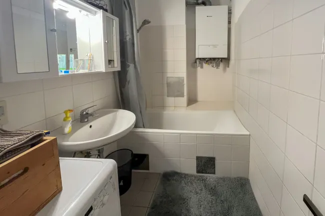 Badezimmer mit Wanne und Waschmaschinenanschluss