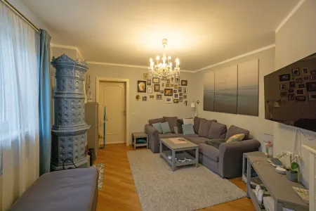 Wohnzimmer mit Kachelofen und Verbindungstür zu Wohnung 2