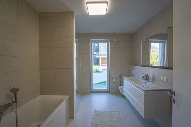 Badezimmer mit Wanne, bodengleicher Dusche, Waschtisch, Spiegelschrank und WC